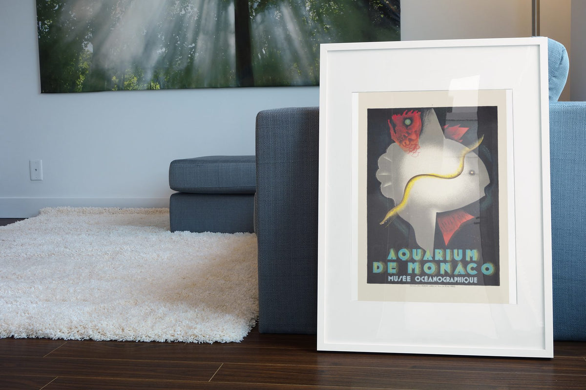Aquarium de Monaco poster leaning beside a blue sofa