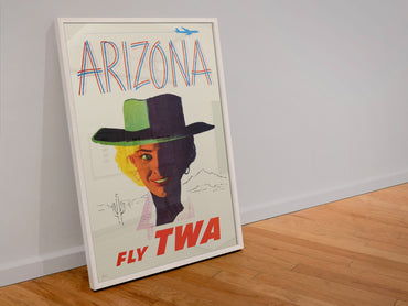 Arizona Fly TWA Cowgirl poster in a white frame leaning against a wall