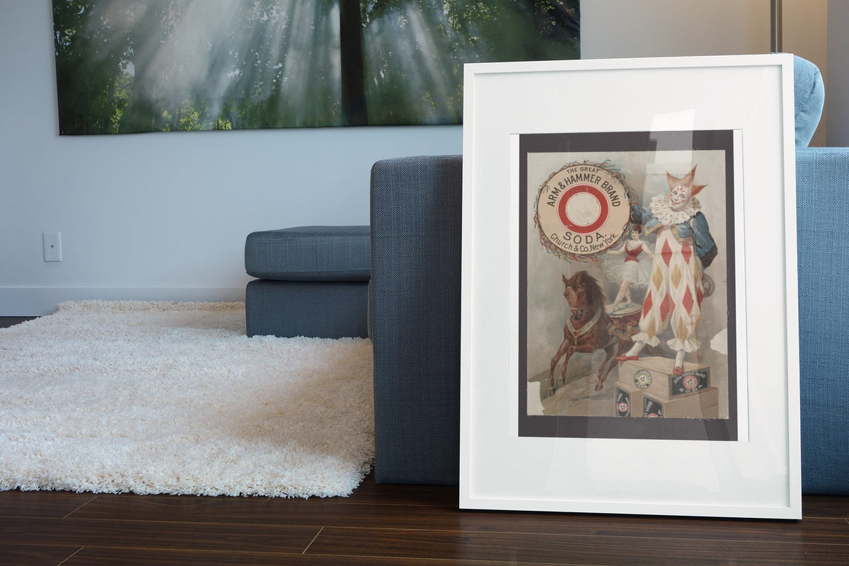 Arm and Hammer Soda Clown poster leaning beside a blue sofa