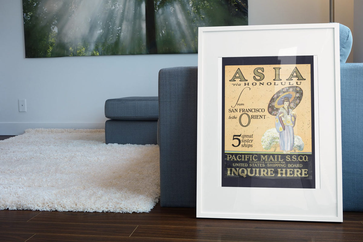 Asia via Honolulu Pacific Mail poster leaning beside a blue sofa