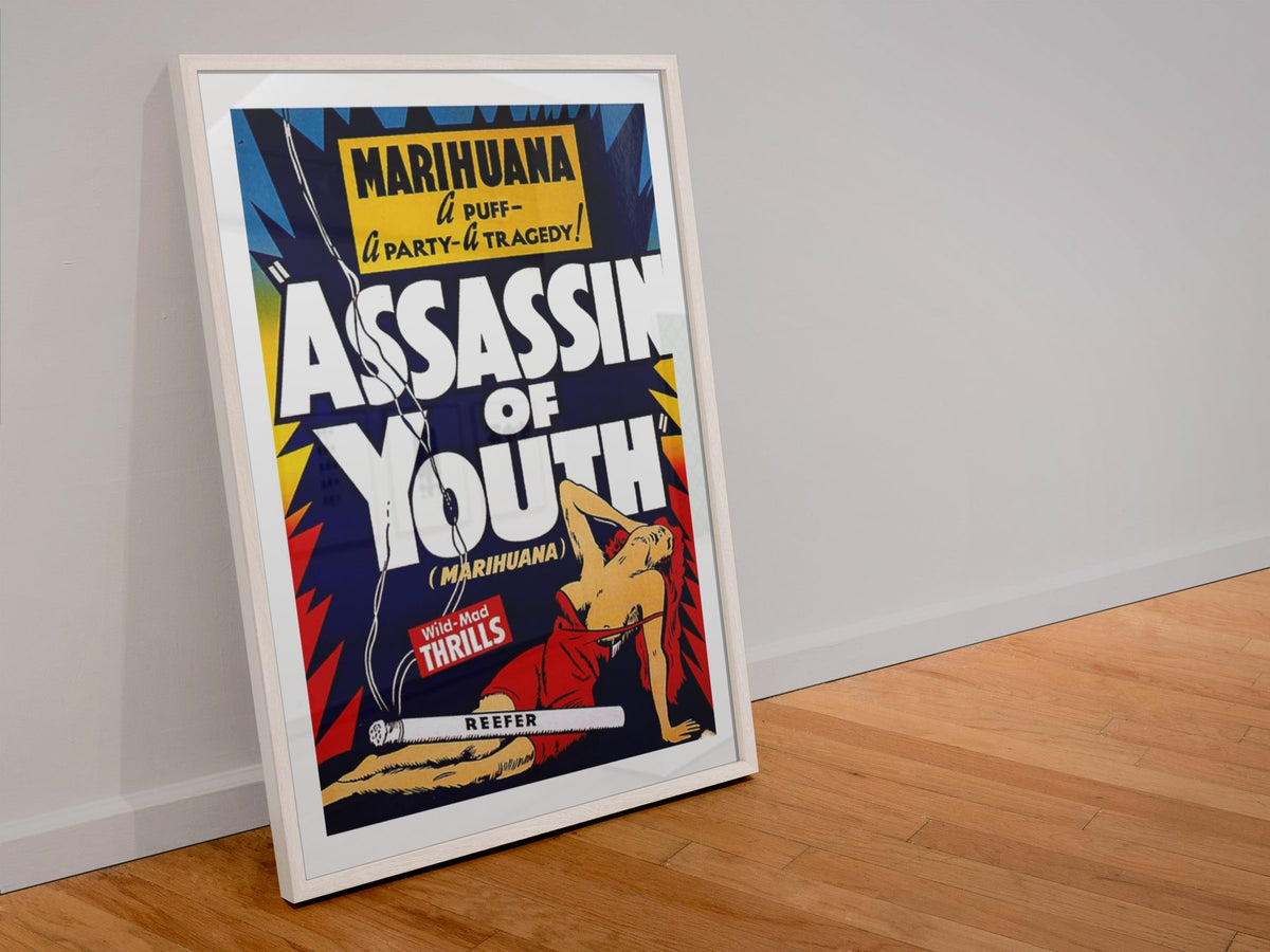 Assassin of Youth poster in a white frame leaning against a wall