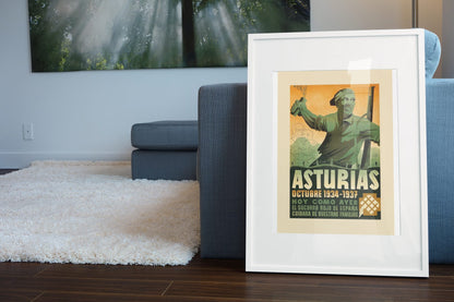 Asturias 1934-1937 poster leaning beside a blue sofa