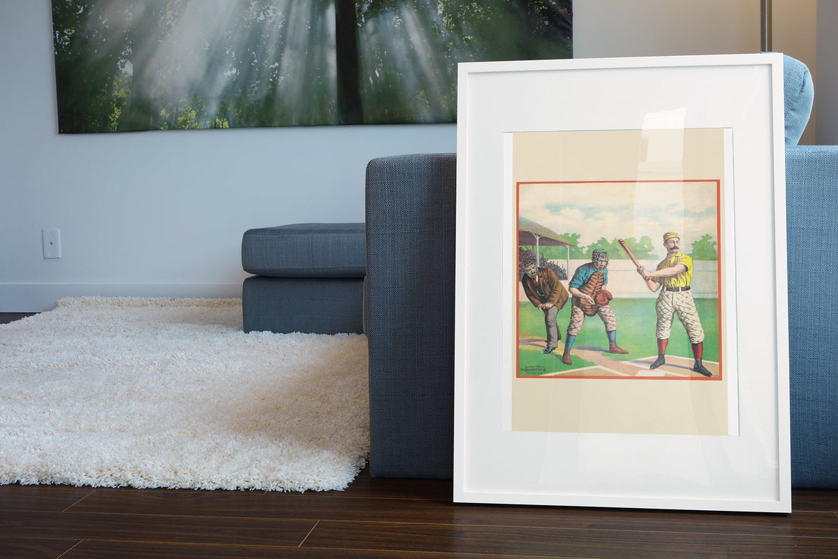 Baseball Batter 1895 poster leaning beside a blue sofa