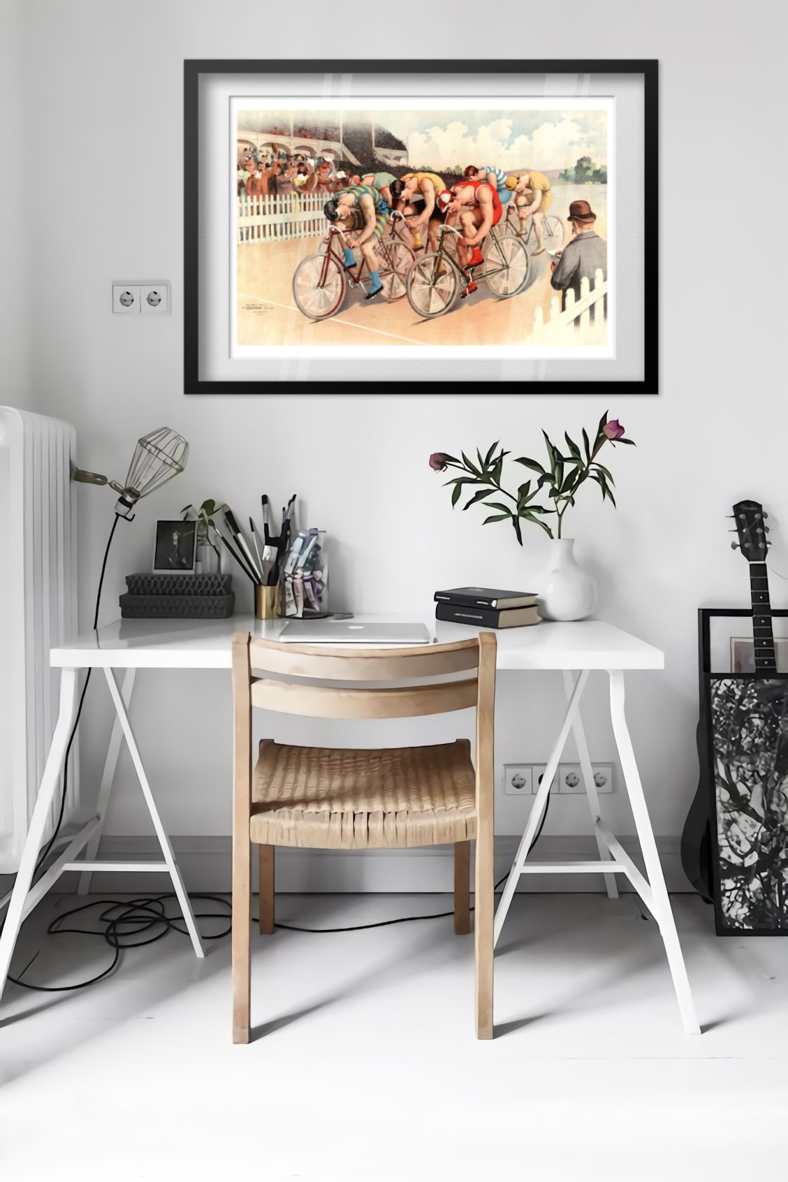 Bicycle Race poster framed above a desk in a bright white room