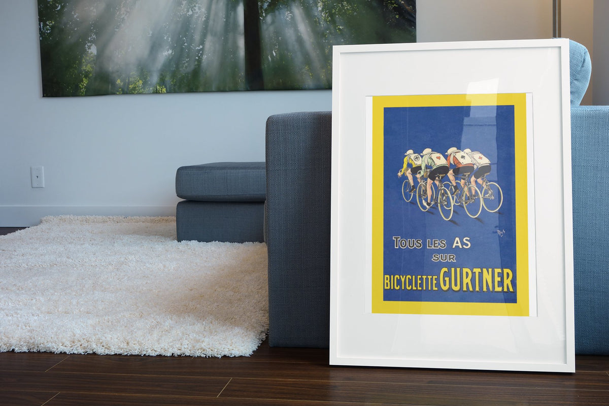 Bicyclette Gurtner poster leaning beside a blue sofa