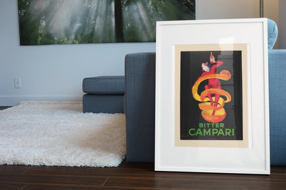 Bitter Campari by Cappiello poster in a white frame leaning beside a blue sofa