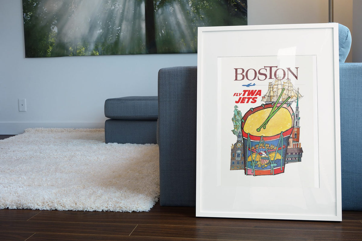 Boston Fly TWA Jets poster leaning beside a blue sofa