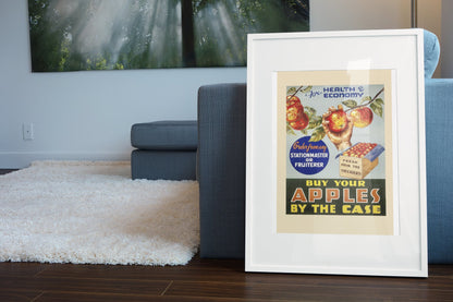 Buy Apples by the Case 1935 poster in a white frame leaning beside a blue sofa