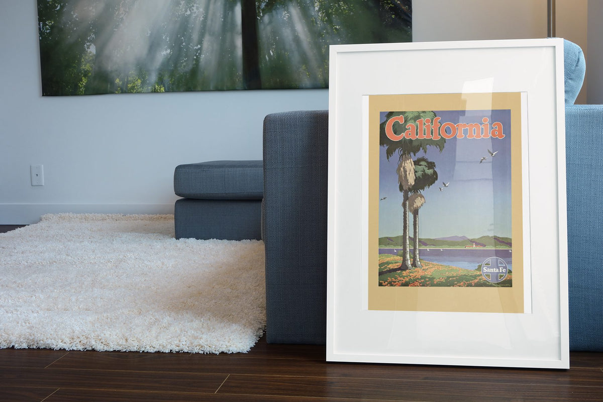 California Santa Fe poster leaning beside a blue sofa