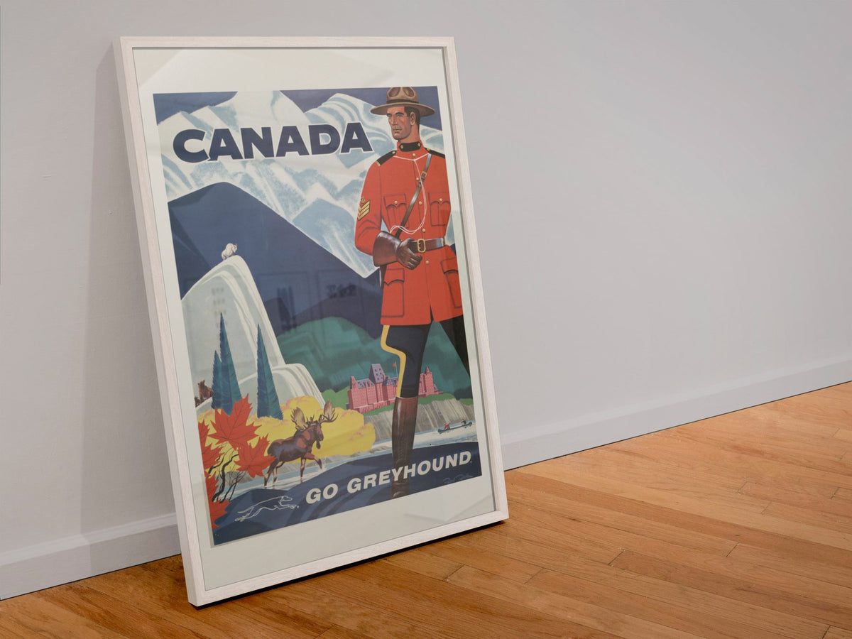 Canada Mountie Greyhound poster in a white frame leaning against a wall