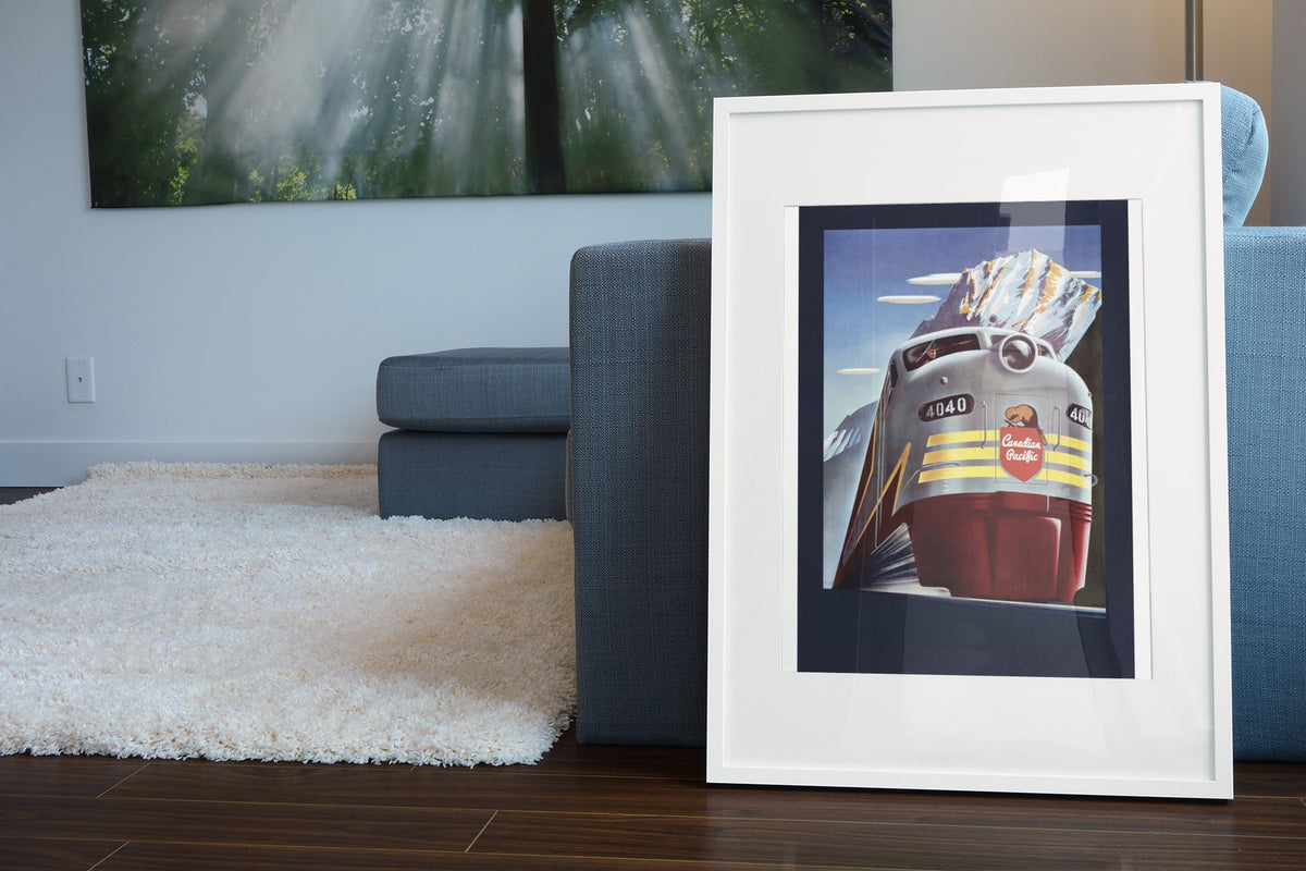 Canadian Pacific Locomotive 1950s poster leaning beside a blue sofa