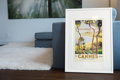 Cannes Cote d Azur poster leaning beside a blue sofa