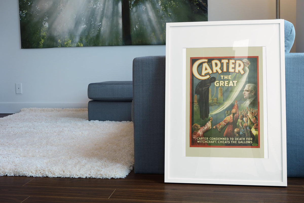 Carter the Great Condemned for Witchcraft poster leaning beside a blue sofa