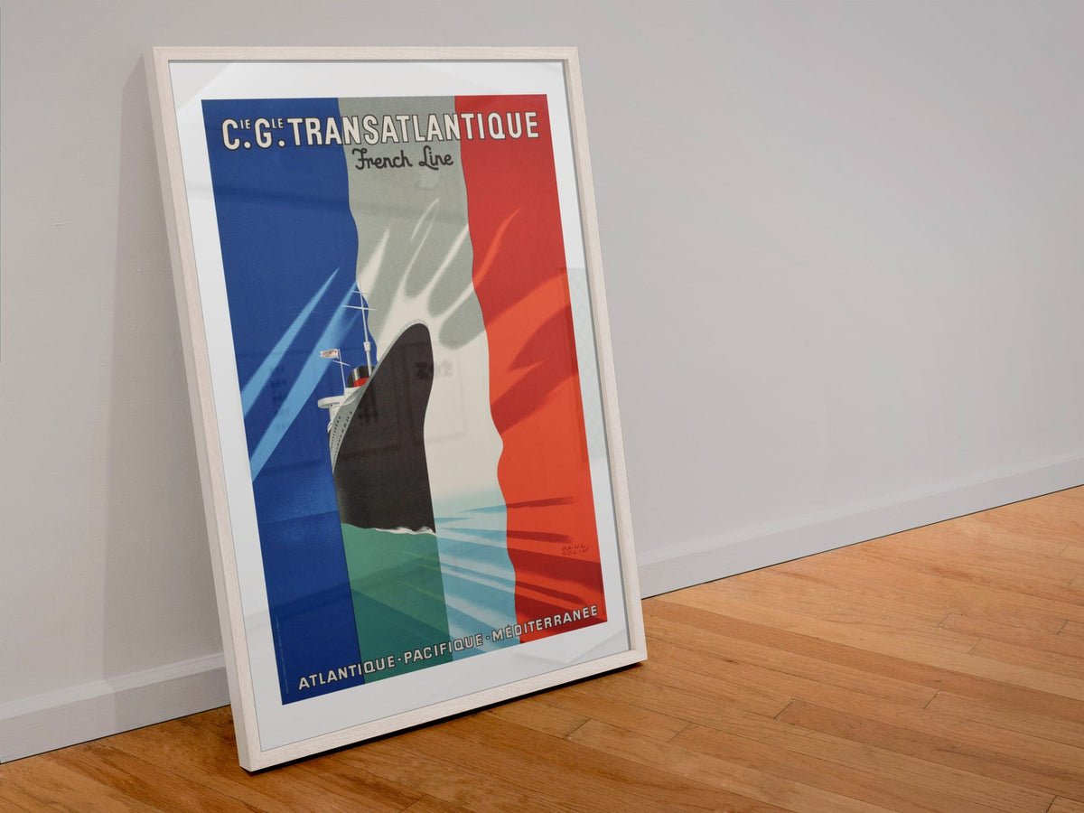 CGT Transatlantique French Line poster in a white frame leaning against a wall
