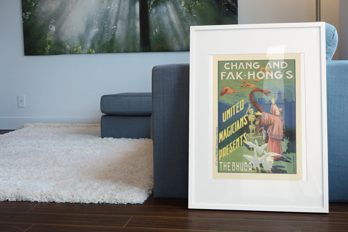Chang and Fak-Hong The Bhuda poster leaning beside a blue sofa