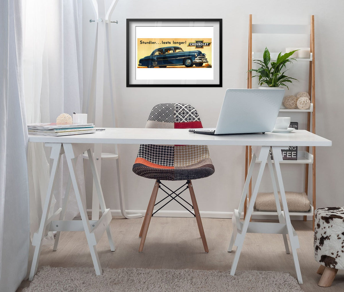 Chevrolet De Luxe 1951 poster framed above a white desk in a home office