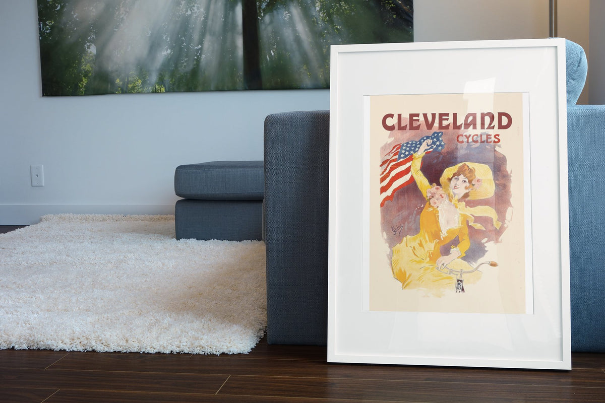 Cleveland Cycles Cheret poster leaning beside a blue sofa