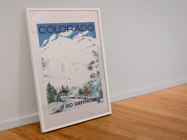 Colorado Go Greyhound poster in a white frame leaning against a wall