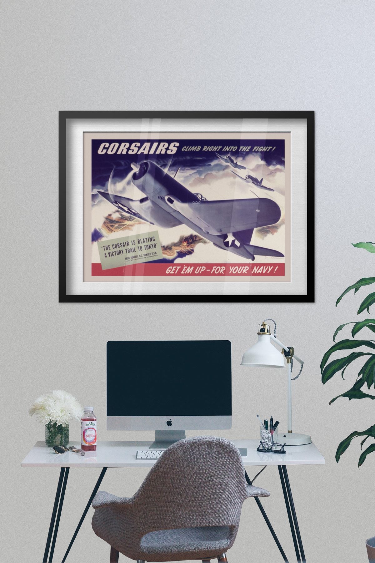 Corsairs Climb Right into the Fight poster framed on a grey wall above a desk