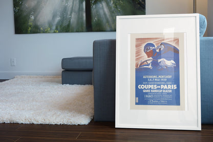 Coupes de Paris Montlhéry 1939 poster in a white frame leaning beside a blue sofa