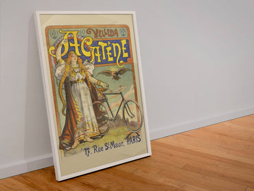 Cycles Acatène Paris bicycle poster in a white frame leaning against a wall