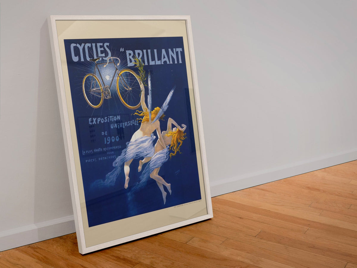 Cycles Brillant 1900 bicycle poster in a white frame leaning against a wall