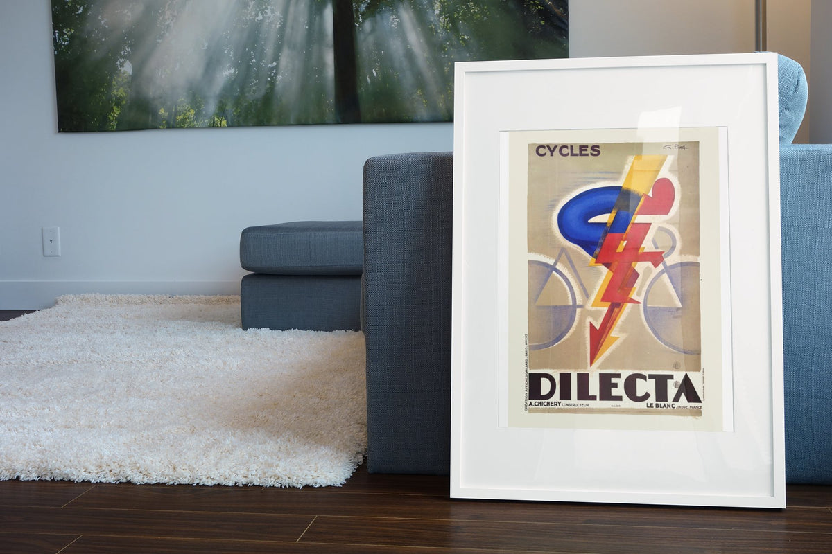 Cycles Dilecta poster leaning beside a blue sofa