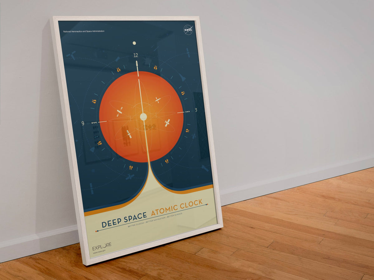Deep Space Atomic Clock, orange poster in a white frame leaning against a wall