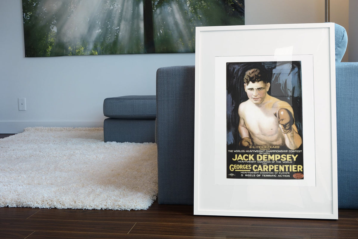 Jack Dempsey vs Georges Carpentier poster leaning beside a blue sofa