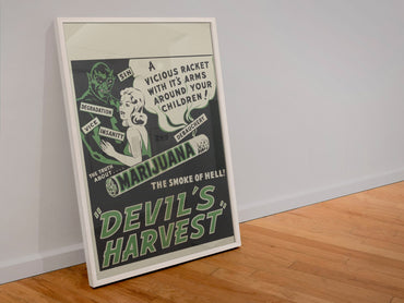 Devils Harvest poster in a white frame leaning against a wall