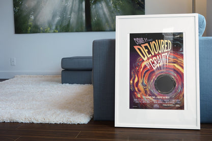 Devoured by Gravity, Cygnus X-1 poster in a white frame leaning beside a blue sofa