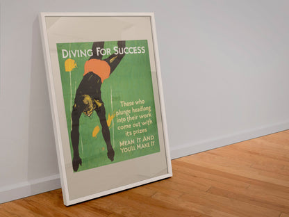 Diving for Success poster in a white frame leaning against a wall