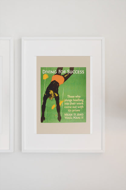 Diving for Success poster in a white frame on a light wall