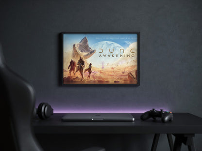 Dune: Awakening Key Art poster in a black frame above a gaming desk