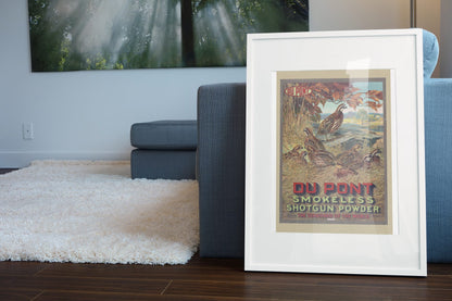 DuPont Smokeless Shotgun Powder poster leaning beside a blue sofa