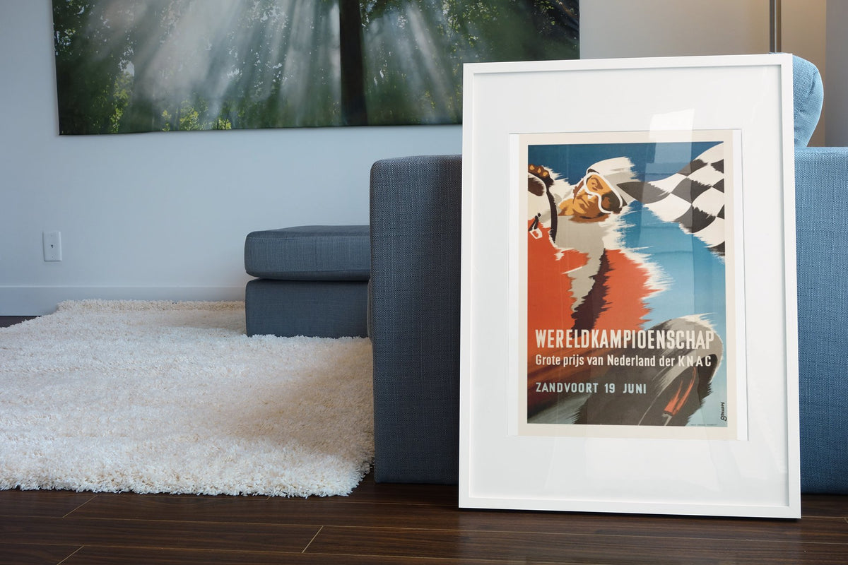 Dutch Grand Prix Zandvoort poster in a white frame leaning beside a blue sofa