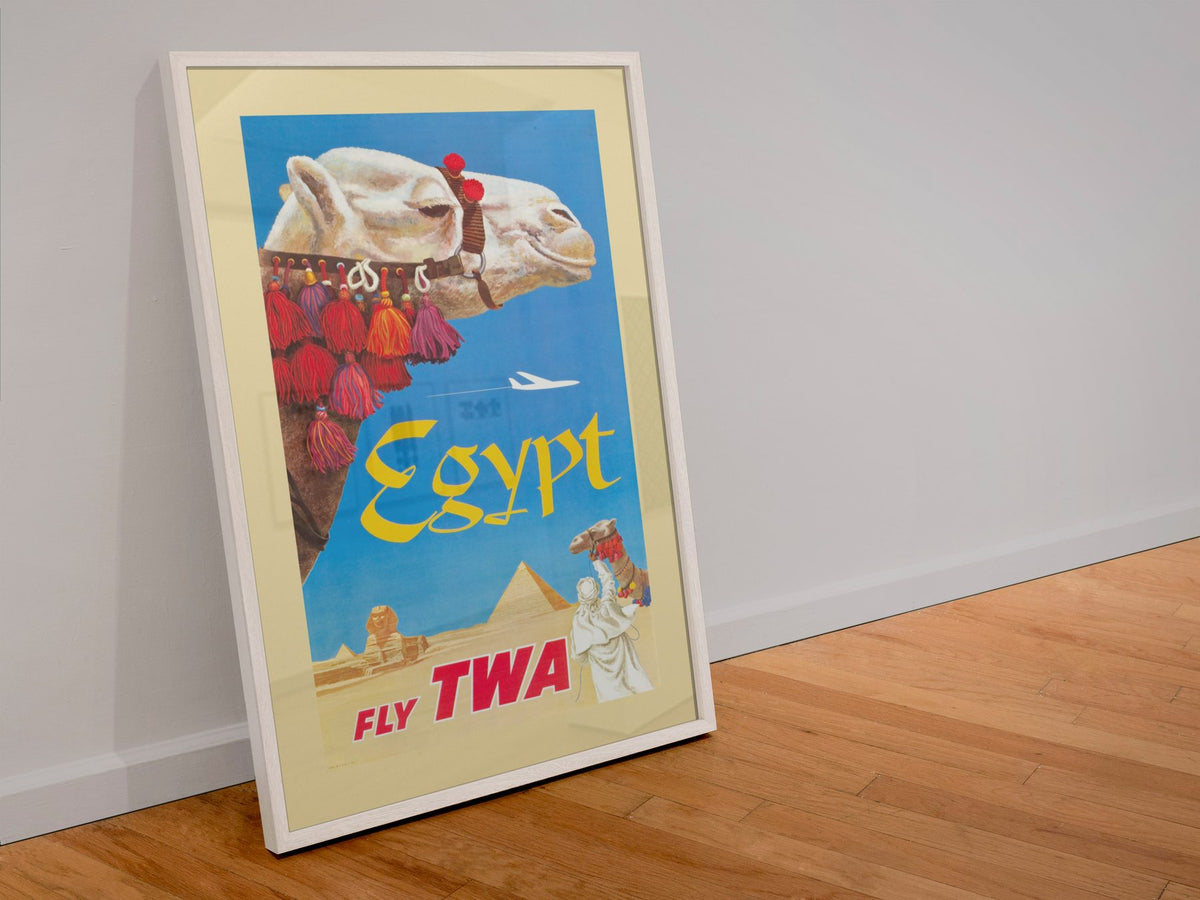 Egypt Fly TWA Camel poster in a white frame leaning against a wall