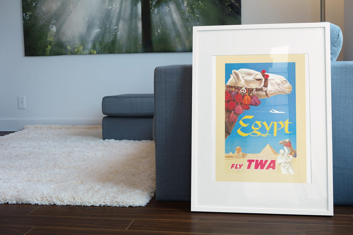Egypt Fly TWA Camel poster leaning beside a blue sofa