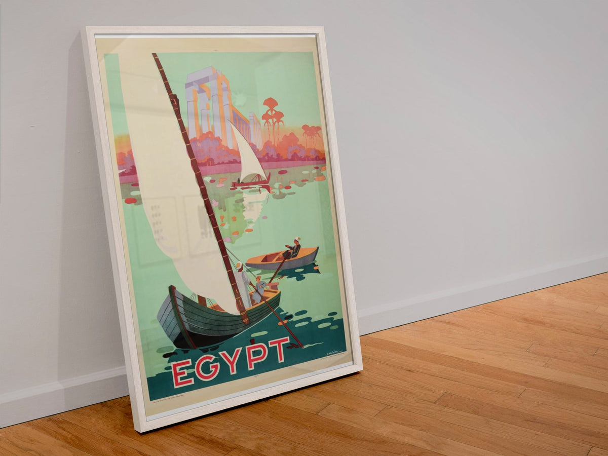 Egypt Sail the Nile poster in a white frame leaning against a wall