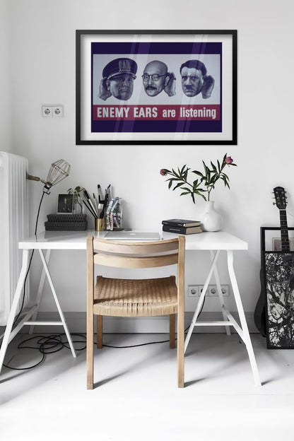Enemy Ears Are Listening poster framed above a desk in a bright white room