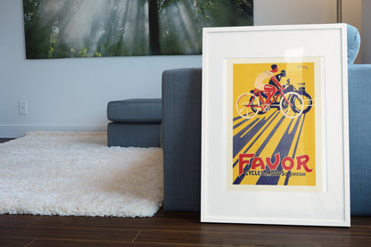 Favor Cycles & Motos poster leaning beside a blue sofa