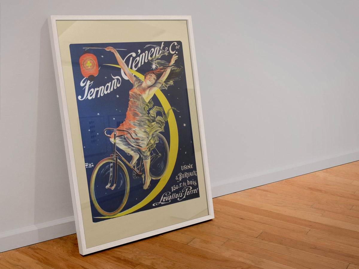 Fernand Clement Cycles poster in a white frame leaning against a wall