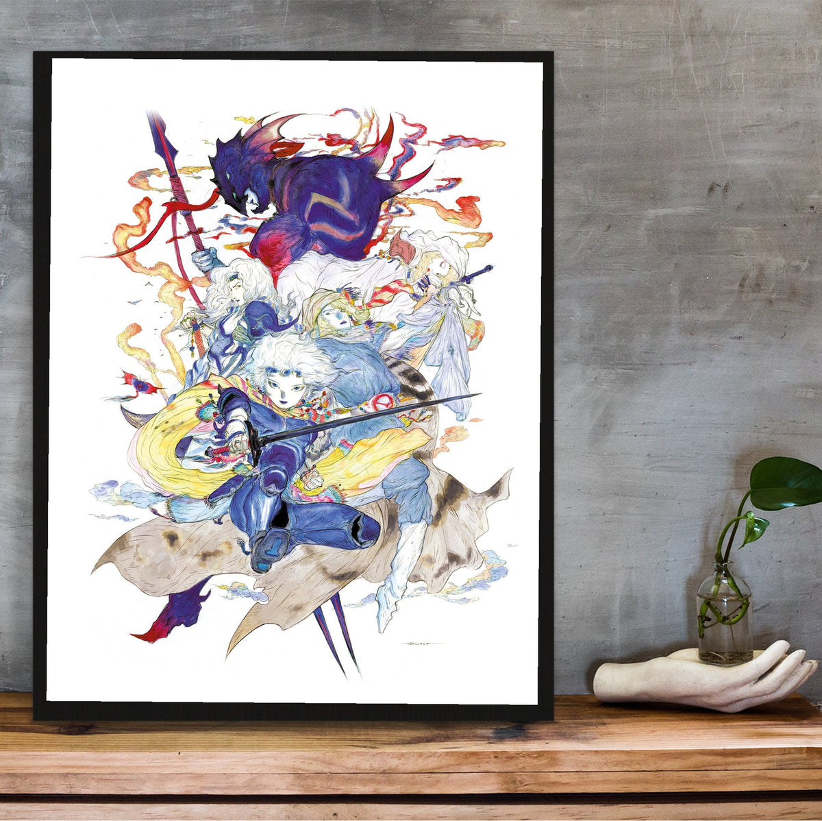 Final Fantasy IV Complete Collection Amano poster in a black frame on a wooden shelf against concrete