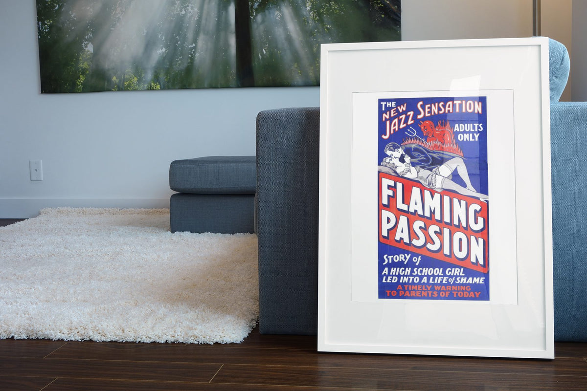 Flaming Passion poster leaning beside a blue sofa
