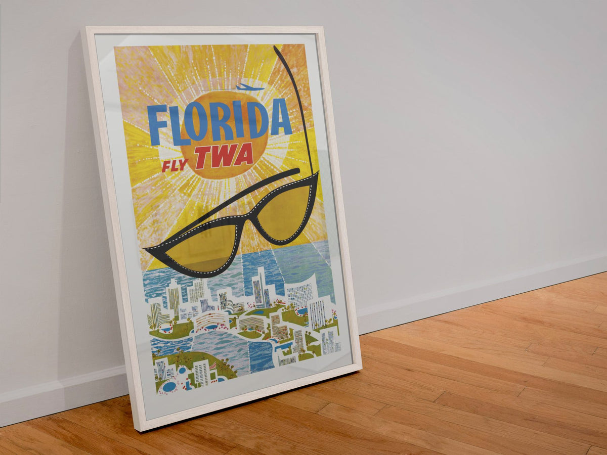 Florida Fly TWA poster in a white frame leaning against a wall