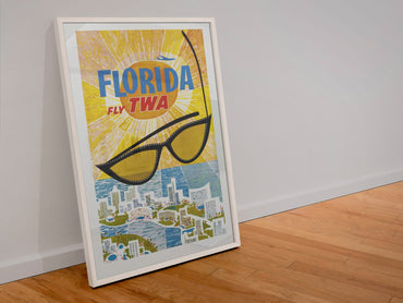 Florida Fly TWA poster in a white frame leaning against a wall