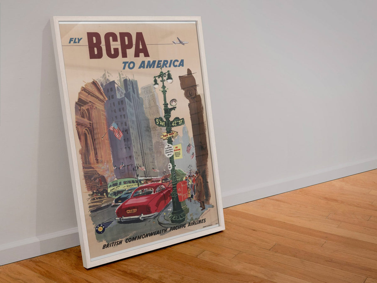 Fly BCPA to America poster in a white frame leaning against a wall