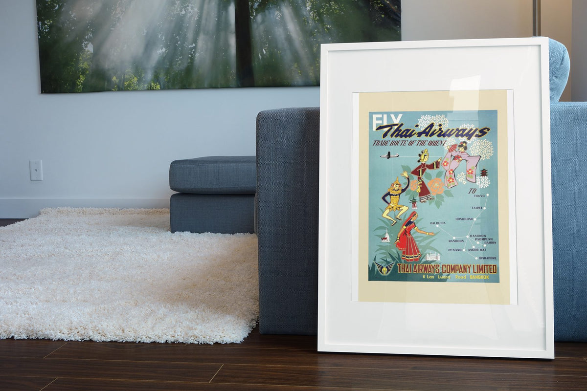 Fly Thai Airways poster leaning beside a blue sofa