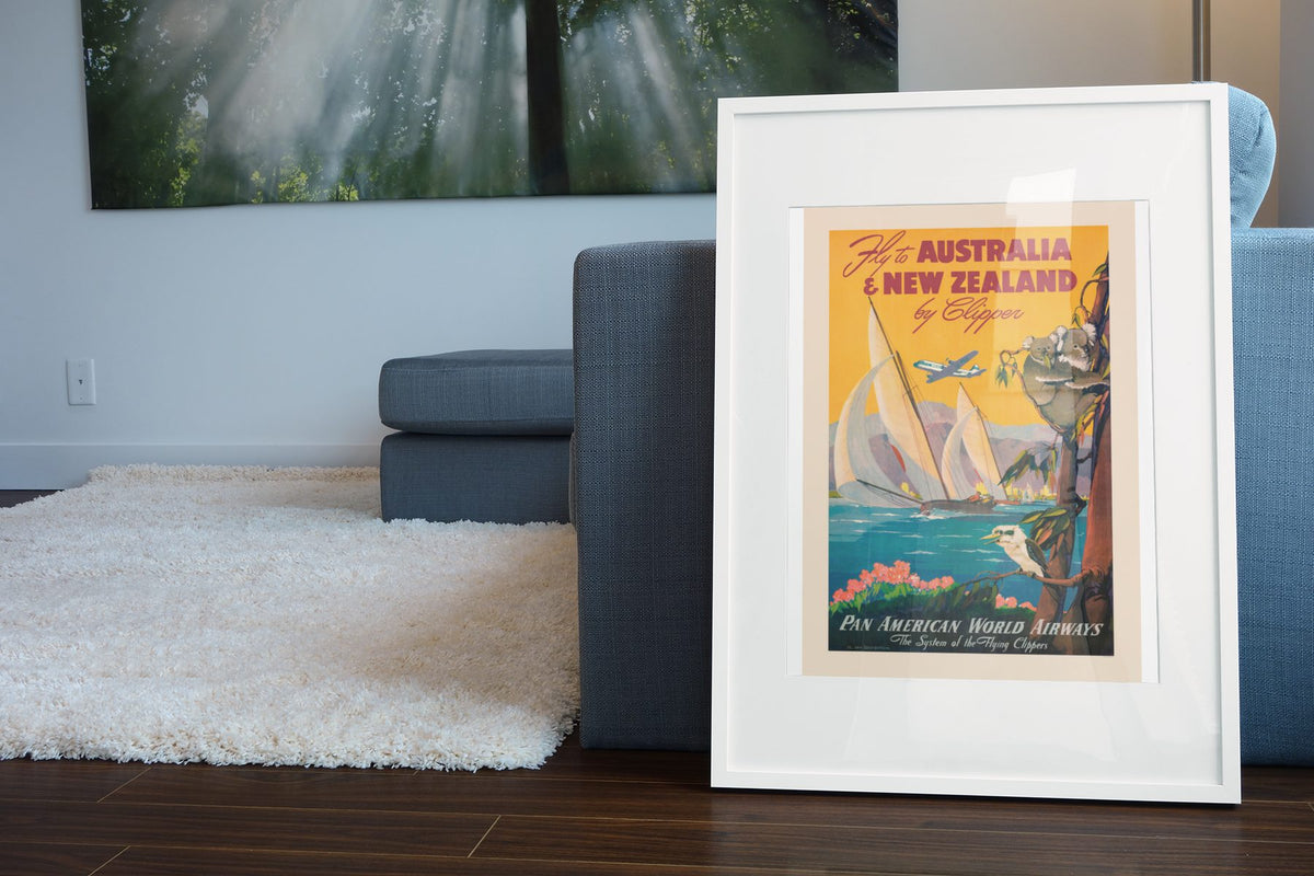 Fly to Australia and New Zealand Pan Am poster leaning beside a blue sofa