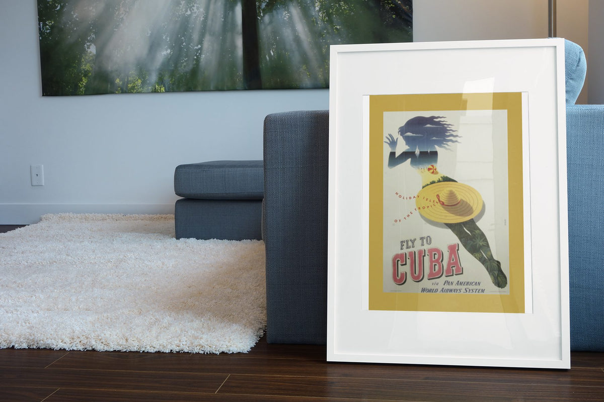 Fly to Cuba Pan American poster leaning beside a blue sofa